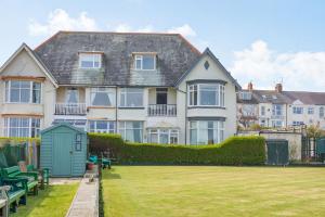 a large house with a green lawn in front of it at Beachside Apartment in Hornsea