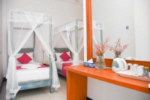 a bedroom with two beds with red pillows at The Entrance Galle Fort in Galle