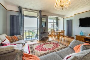 a living room with a couch and a television and a table at Beachside Apartment in Hornsea