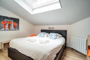 a bedroom with a large bed with a skylight at LA FORESTIERE - Petit havre de paix au Pyla, face aux pins in La Teste-de-Buch