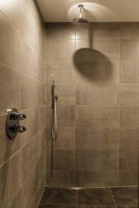 La salle de bains est pourvue d'une douche avec une personne debout. dans l'établissement Boszicht 1 appartement in Oostkapelle, à Oostkapelle