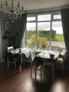 a dining room with two tables and a large window at Dale View bed & breakfast in Holmrook