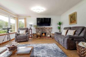 a living room with two couches and a fireplace at 3 bedroom bungalow with htub & private loch access in Crieff