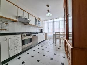 a kitchen with a black and white tiled floor at Piso de 3 habitaciones a 3 minutos de la playa. in Ribeira