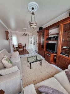 a living room with a couch and a tv at Piso de 3 habitaciones a 3 minutos de la playa. in Ribeira