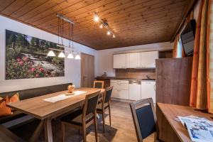a kitchen and dining room with a wooden table and chairs at Landhaus Gredler in Mayrhofen