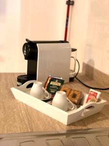 a tray with cups and bread and a coffee maker at Residence D'azeglio in Palermo
