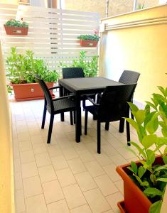 a black table and chairs on a patio with plants at Residence D'azeglio in Palermo