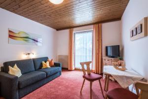 ein Wohnzimmer mit einem Sofa und einem TV in der Unterkunft Landhaus Gredler in Mayrhofen