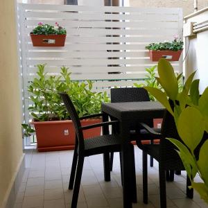 un balcone con tavolo, sedie e piante in vaso. di Residence D'azeglio a Palermo