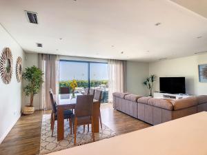 a living room with a couch and a table and a television at Eden Sky by LovelyStay in Prazeres