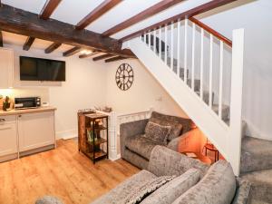 a living room with a couch and a staircase at Middle Cottage in Ashbourne