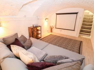 a living room with a couch and a screen at Middle Cottage in Ashbourne