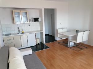 a kitchen and living room with a table and a couch at Apartments Dinko in Duće