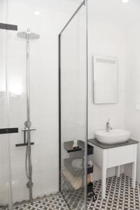 La salle de bains est pourvue d'un lavabo et d'une douche en verre. dans l'établissement Vila Luxo da Praia, à Casal da Lagoa Seca