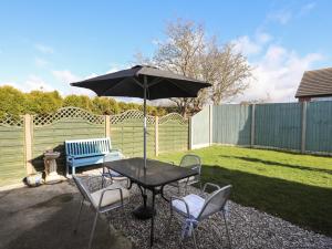 a table and chairs with an umbrella in a yard at Glantraeth in Holyhead