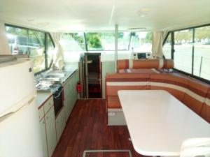 a kitchen with a white table in a bus at Bateau 6 personnes sans permis terrasse à quai ou option navigation in Béziers