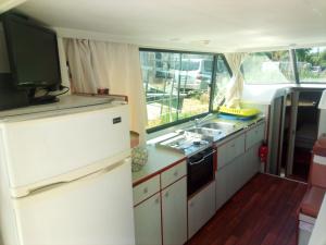 uma cozinha com um frigorífico branco e um lavatório em Bateau 6 personnes sans permis terrasse à quai ou option navigation em Béziers