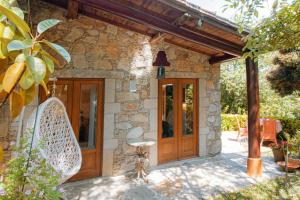 ein Steinhaus mit Holztüren und einer Terrasse in der Unterkunft iCHILL Villa Esquina 204 - Connected With Nature in Riba de Âncora