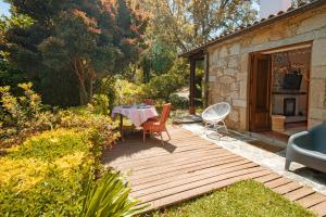 eine Holzterrasse mit einem Tisch und Stühlen im Garten in der Unterkunft iCHILL Villa Esquina 204 - Connected With Nature in Riba de Âncora