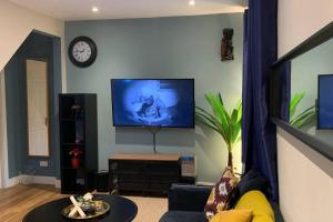 a living room with a couch and a tv on a wall at Stunning 1-Bed Apartment in London in London