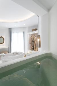 a bedroom with a pool of water in a bath tub at Majestique of Naxos boutique hotel in Naxos Chora