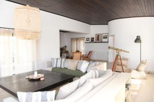 a living room with a white couch and a table at Vila Luxo da Praia in Casal da Lagoa Seca