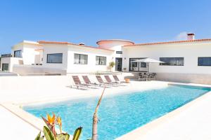 a villa with a swimming pool and a house at Vila Luxo da Praia in Casal da Lagoa Seca