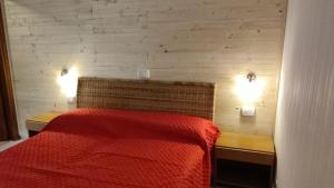 a bedroom with a red bed and two lights at La Casetta Di Vassena in Oliveto Lario
