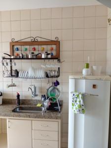 eine Küche mit einer Spüle und einem weißen Kühlschrank in der Unterkunft Apartamento Aconchegante com Estacionamento in Uberlândia