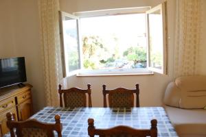 a living room with a table and a window at Olive apartments in Grebaštica