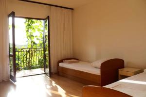 a bedroom with a bed and a door to a balcony at Olive apartments in Grebaštica