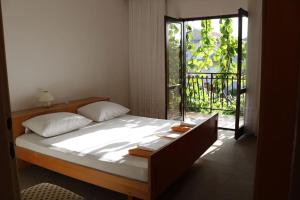 a bedroom with a large bed with a window at Olive apartments in Grebaštica