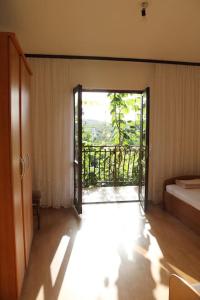 a room with a bed and a door to a balcony at Olive apartments in Grebaštica