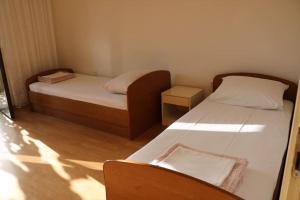 a small room with two beds and a chair at Olive apartments in Grebaštica +14 photos