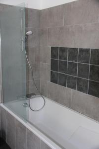 wanna z prysznicem ze szklanymi drzwiami w obiekcie Au Figuier du Gué w mieście Lantillac +32 zdjęcia