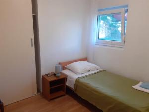 a small bedroom with a bed and a window at Apartments Marija in Krk