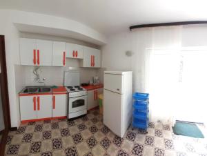 a kitchen with red and white cabinets and a stove at Apartments Marija in Krk