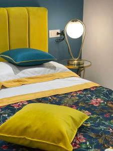 ein gelbes Bett mit gelbem Kissen und einer Lampe in der Unterkunft Marina Luxury Apartments in Ischia