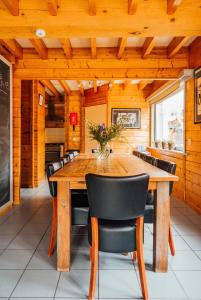 a dining room with a wooden table and black chairs at Ride by the Sea Guesthouse in Koudekerke