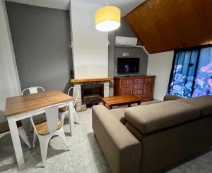 un soggiorno con divano e tavolo di Alojamientos Rurales Cuatro Estaciones ad Arroyo Frio