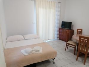 a bedroom with a bed with towels on it at Apartments Dinko in Duće