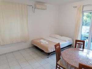 una camera con un letto, un tavolo e una finestra di Apartments Dinko a Duće