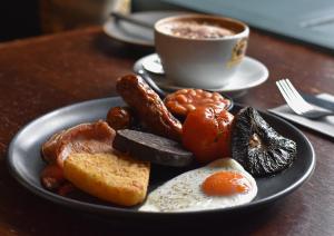 um prato de comida de pequeno-almoço com uma chávena de café em The Percy Arms em Chatton