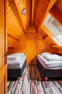 a bedroom with two beds in a wooden cabin at Ride by the Sea Guesthouse in Koudekerke