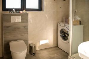 a bathroom with a toilet and a washing machine at Apartments Suzy in Šibenik +48 photos