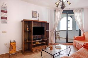 Una sala de estar con un sofá y un televisor. en Apartamento Atlanterra Sol, en Zahara de los Atunes