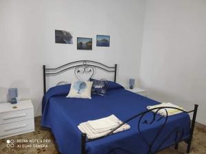 a bedroom with a blue bed with blue sheets at Casa vacanze Lino e Iolanda in Pollara