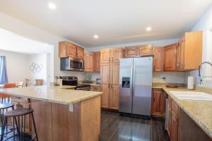 a kitchen with wooden cabinets and a stainless steel refrigerator at Spacious 4 bedroom house close to everything! in Salida