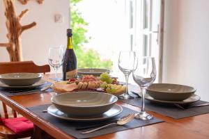Mountain House VENI في جابلاناك: طاولة مع طبق من الطعام وكؤوس النبيذ